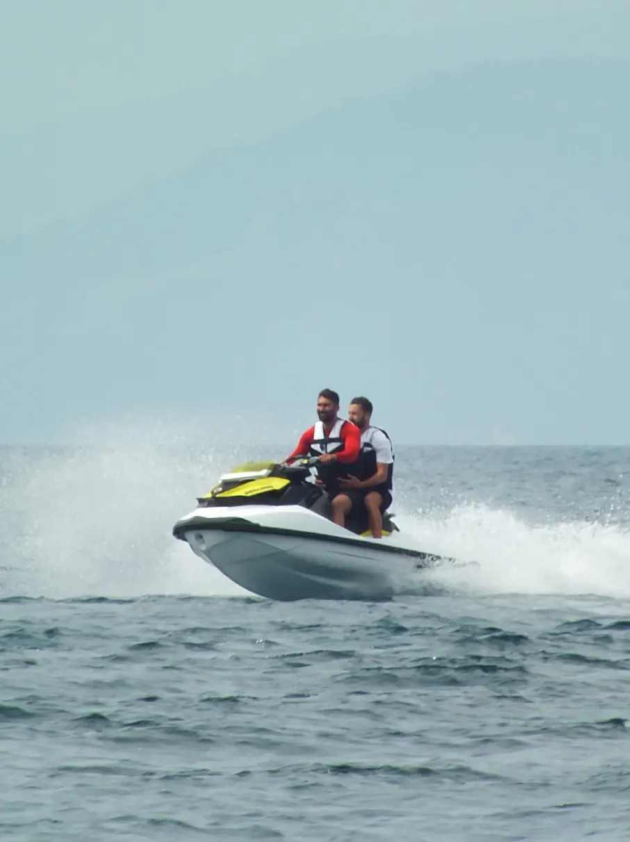 Two men riding a jet ski on the ocean